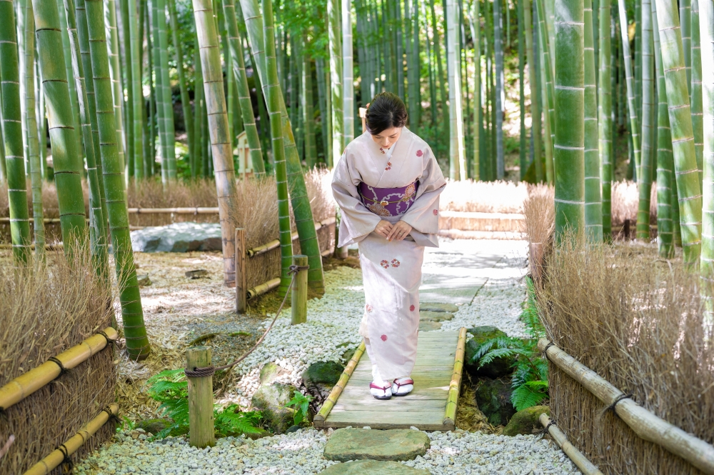 お客さんをお見送りする宿のおかみ